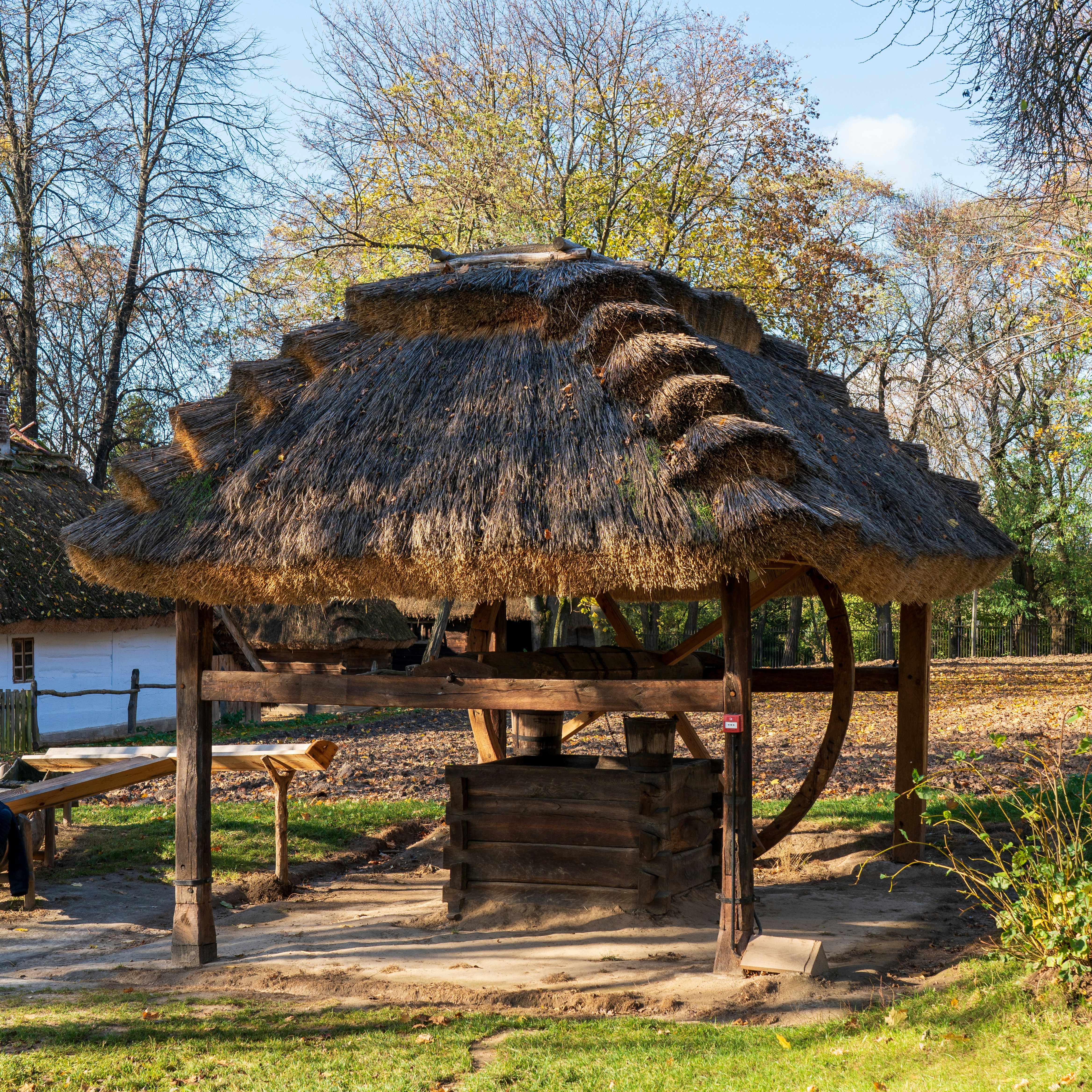 a hut with a thatched roof in a park