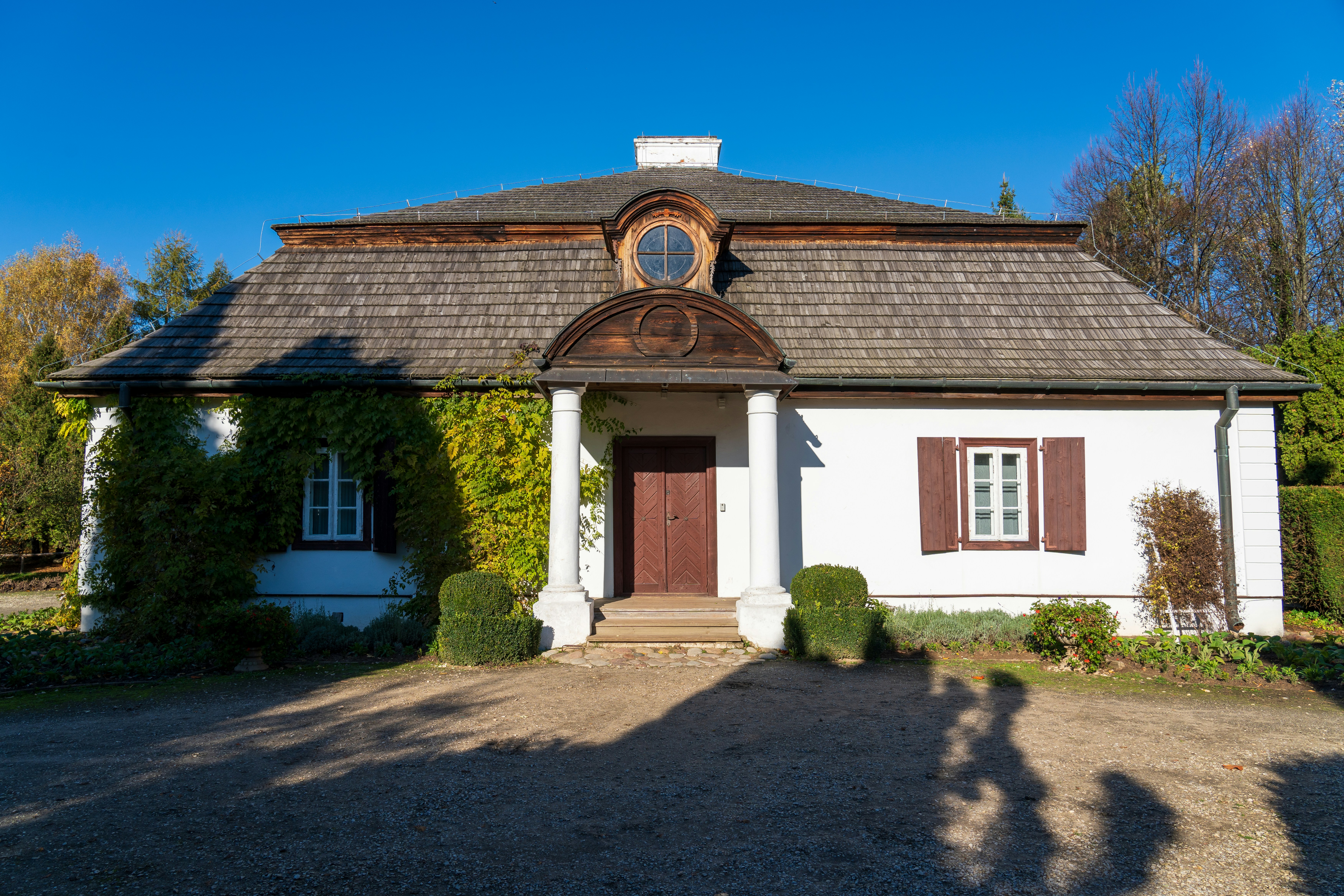 a white house with brown shutters and a brown door