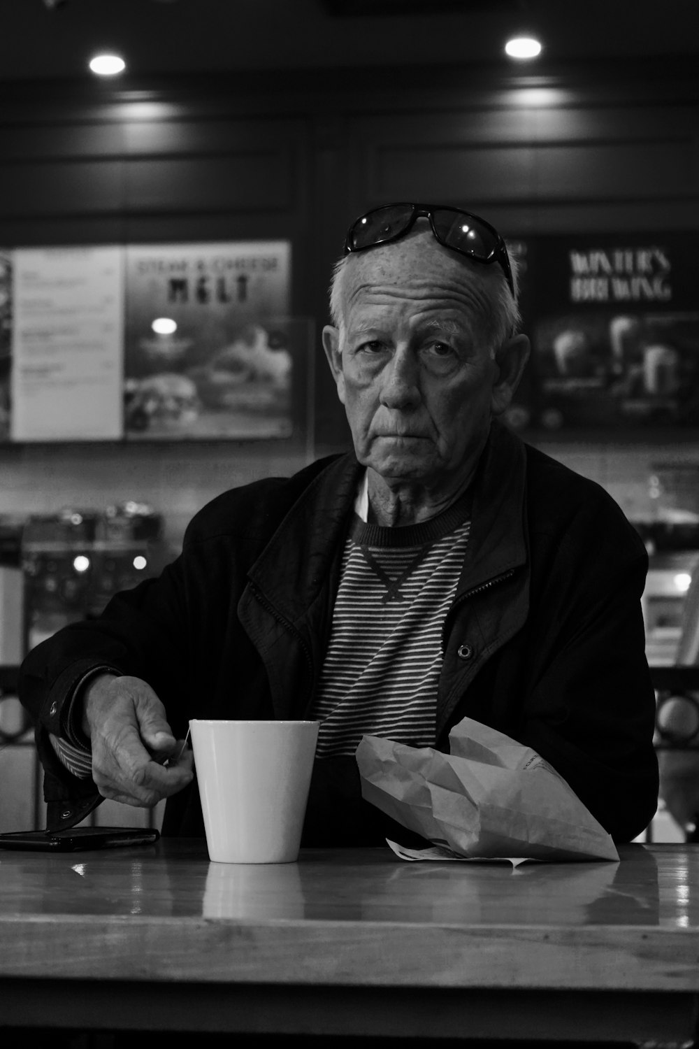 a man sitting at a table with a cup of coffee