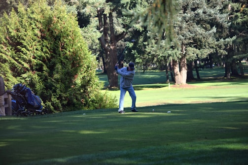 A golfer stretching before a morning practice session on a lush green course