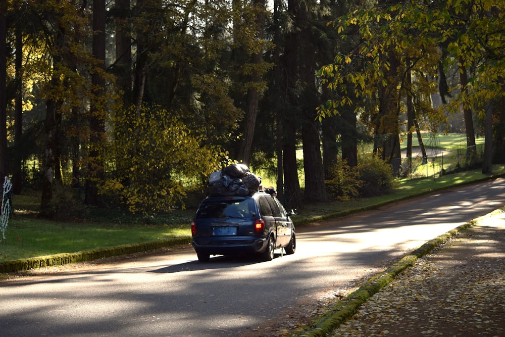 a car with luggage on the back driving down a road