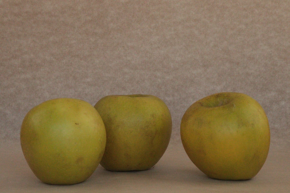 a group of three apples sitting next to each other