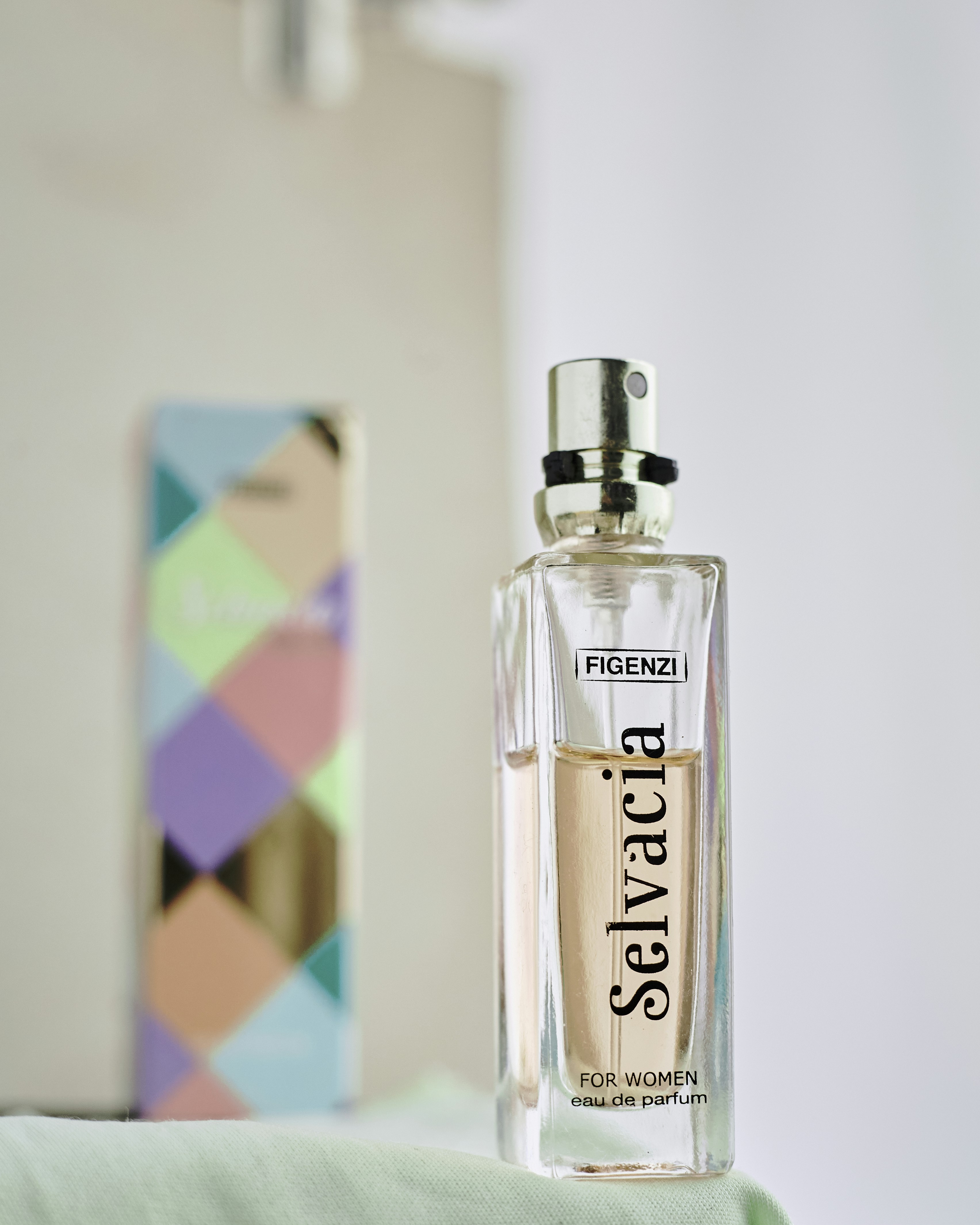 Two women smiling and holding small bottles