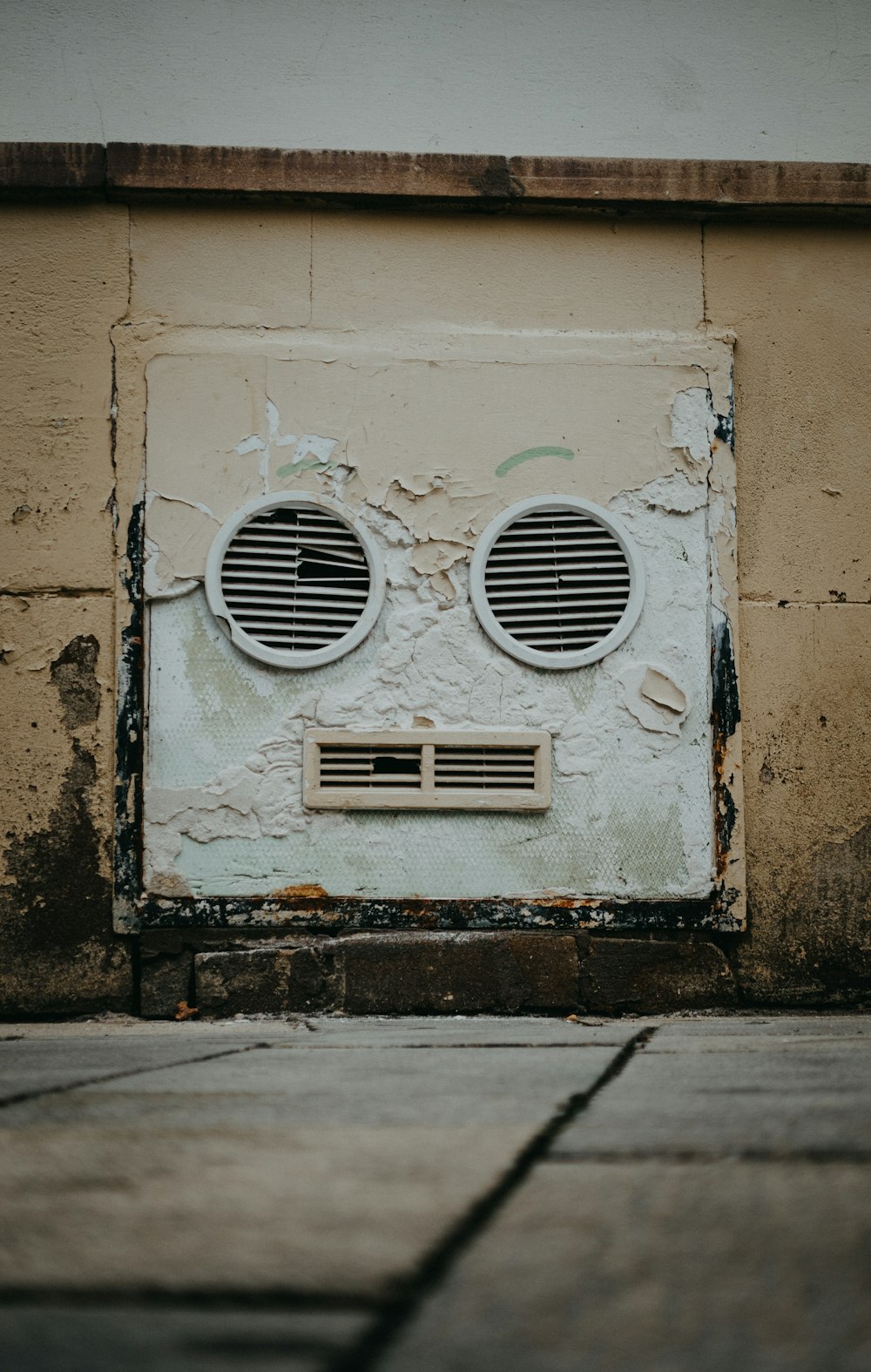 a white wall with two round windows on it