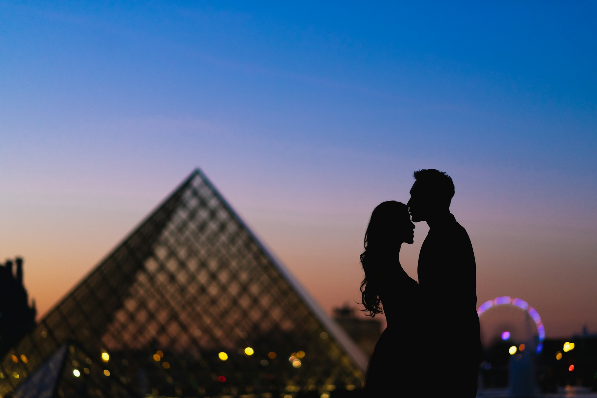 a man and a woman standing in front of a pyramid