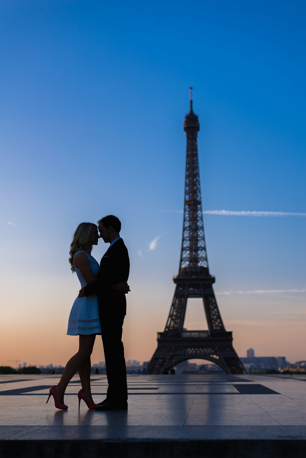 a couple kissing in front of the eiffel tower