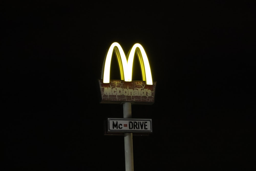 a mcdonald's sign is lit up at night