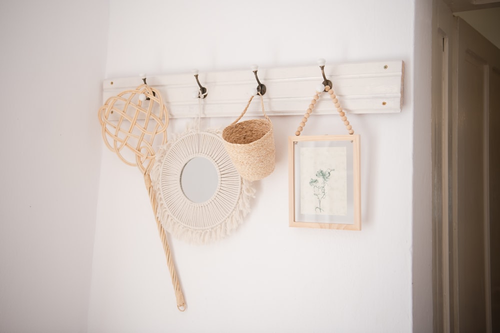 a white coat rack with two baskets hanging on it
