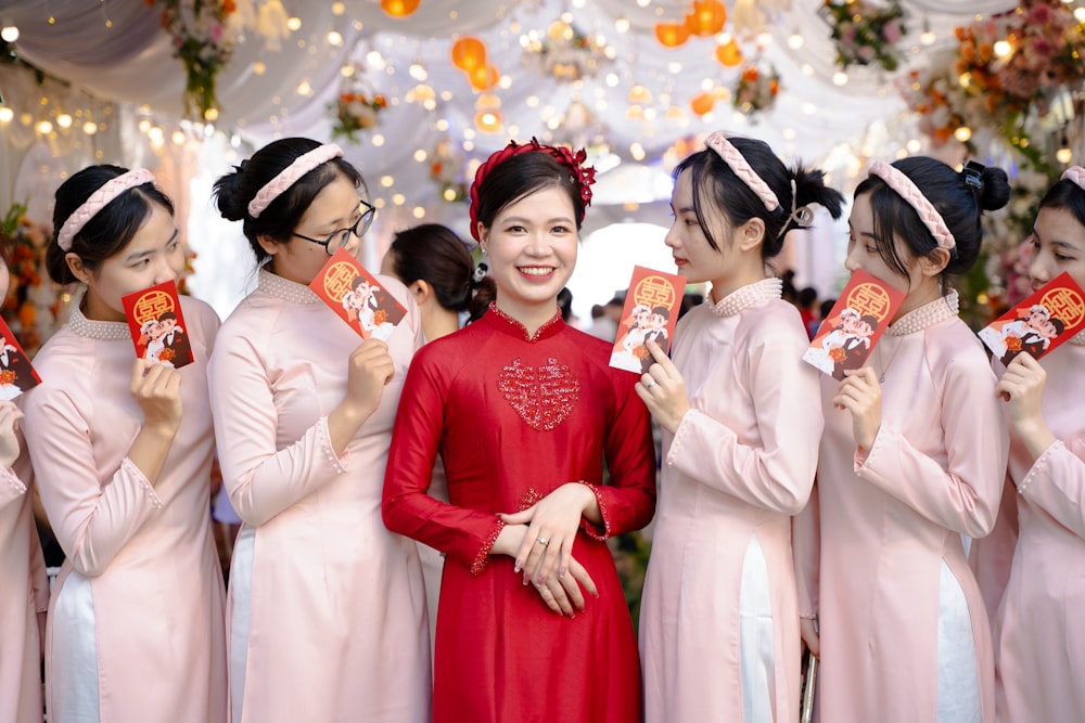 a group of women in pink dresses standing next to each other