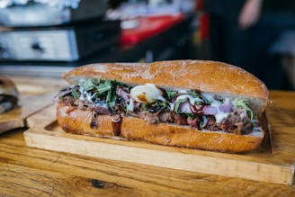 a sandwich on a cutting board on a table