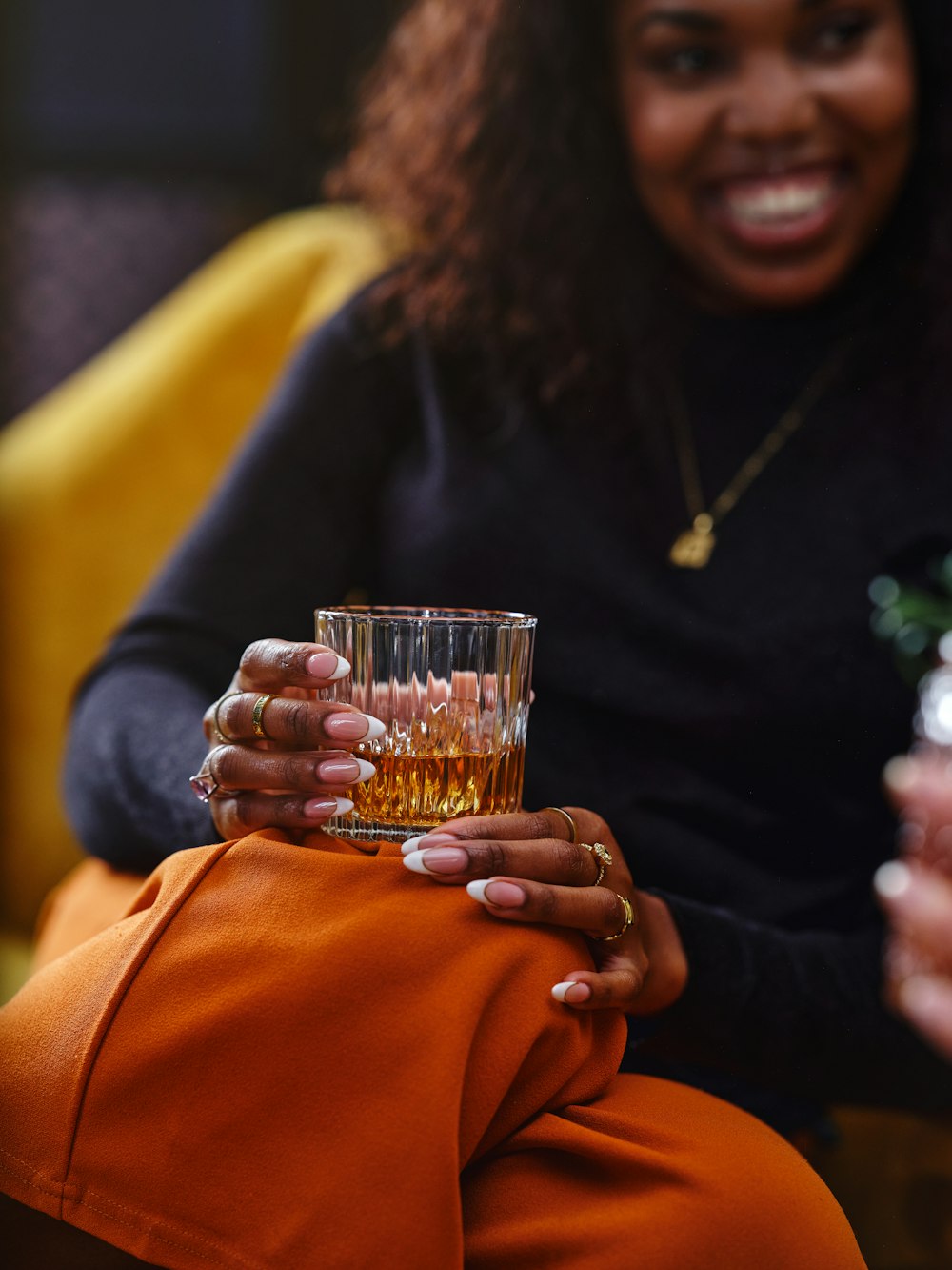 a woman holding a glass of alcohol in her hand