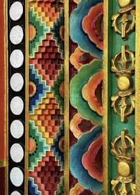 A vibrant handmade painting featuring traditional Indian motifs in deep reds and gold accents.