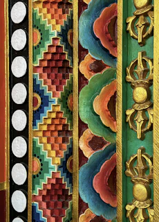 A vibrant handmade painting featuring traditional Indian motifs in deep reds and gold accents.
