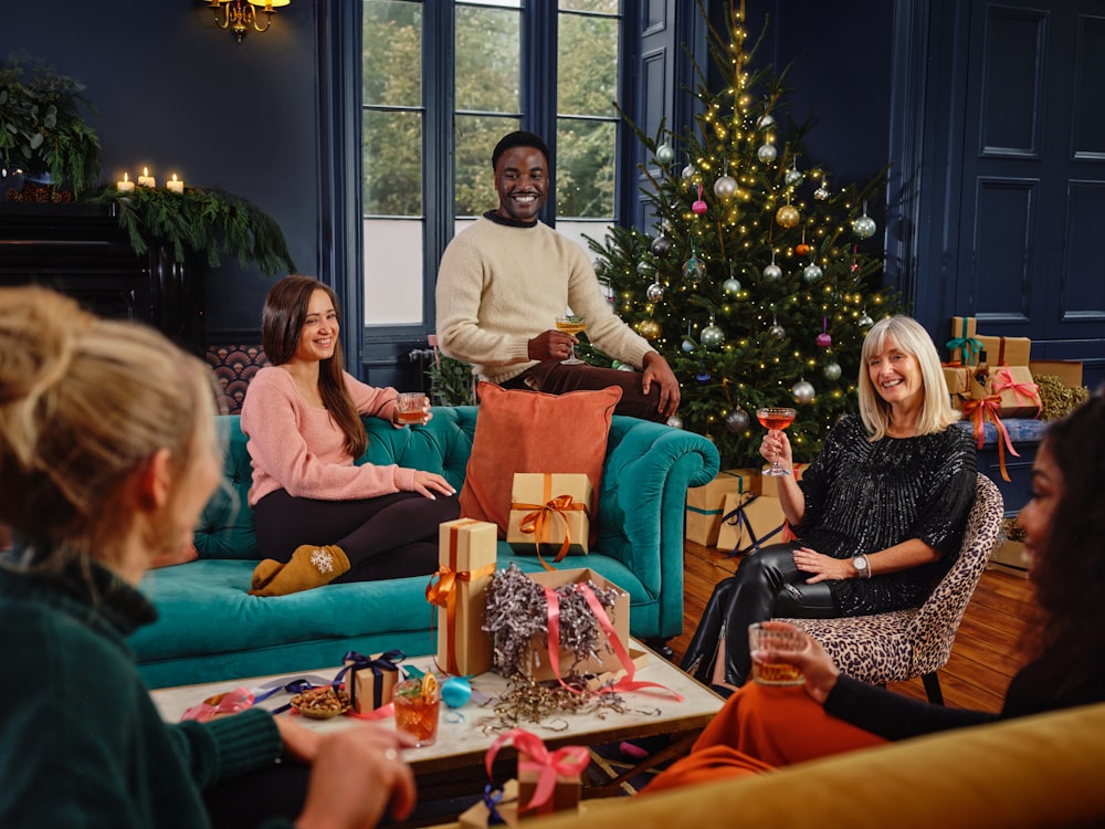 Eine Gruppe von Menschen sitzt um einen Weihnachtsbaum herum
