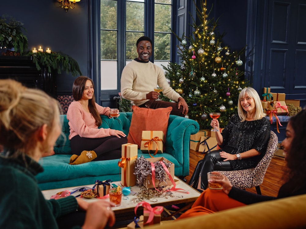 a group of people sitting around a christmas tree