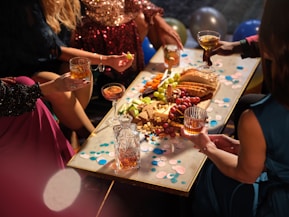 a group of people sitting around a table with food and drinks