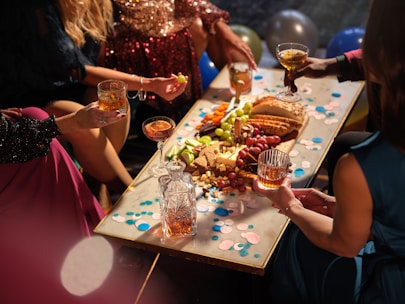 a group of people sitting around a table with food and drinks