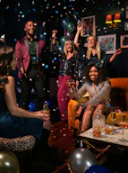 a group of people celebrating with confetti and balloons