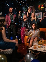 a group of people celebrating with confetti and balloons