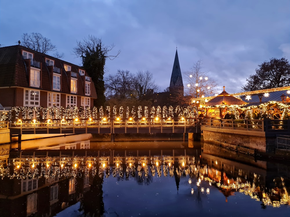 a river with lights on it and buildings in the background