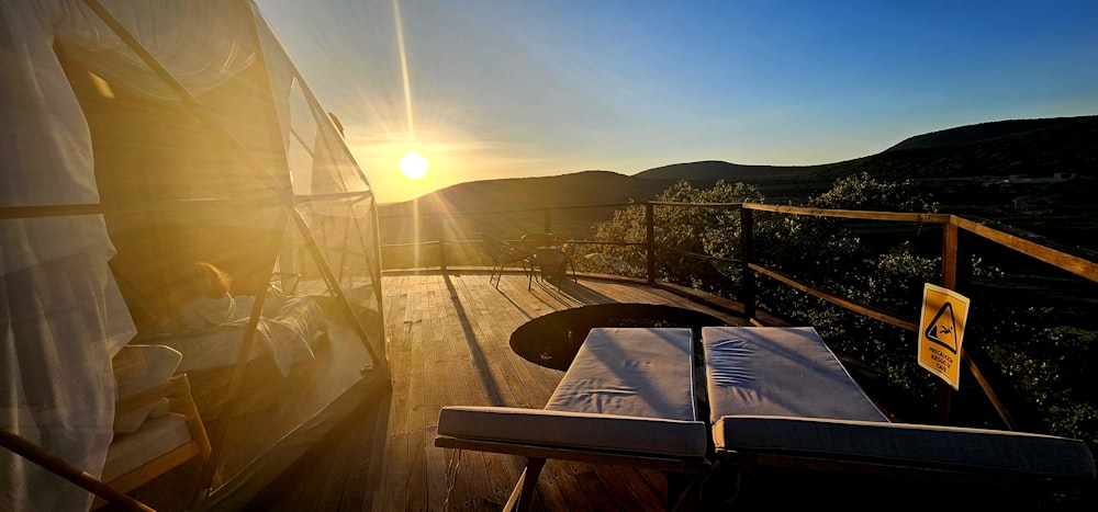 the sun is setting over a deck with a book on it