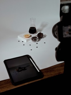 a table topped with a tablet computer next to a cup of coffee