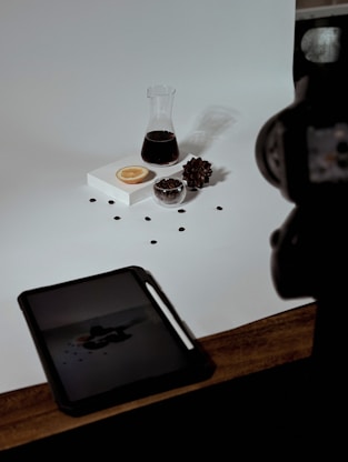 a table topped with a tablet computer next to a cup of coffee