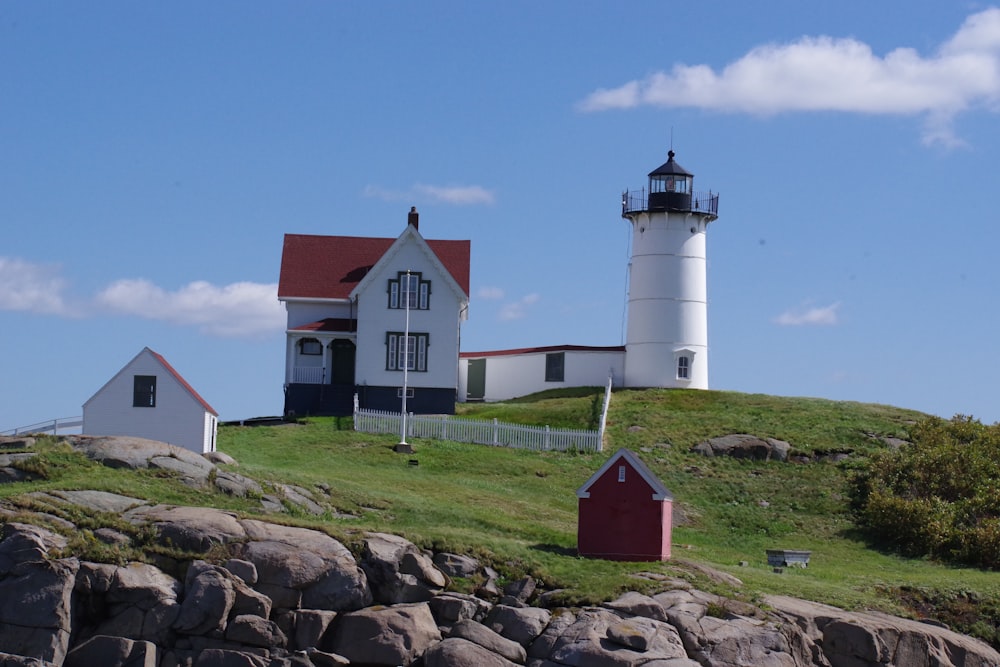 a lighthouse on top of a hill with a red roof