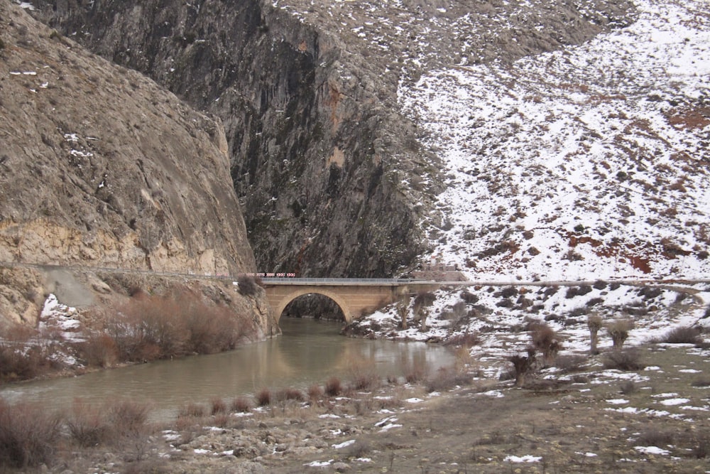 eine Brücke über einen Fluss mitten in einem Berg