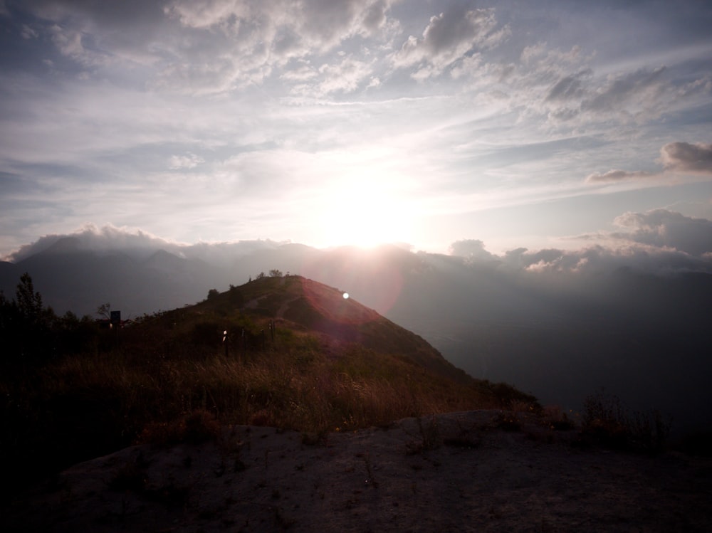 the sun is setting on the top of a mountain