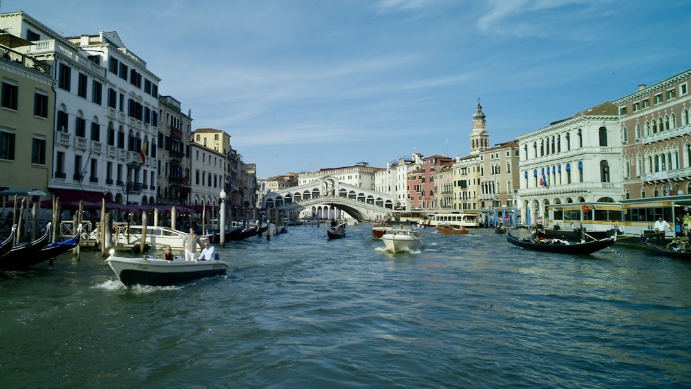 a canal with several boats in it and a bridge in the background