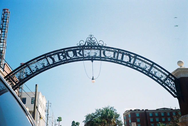 a large metal arch sign over ybor city street
