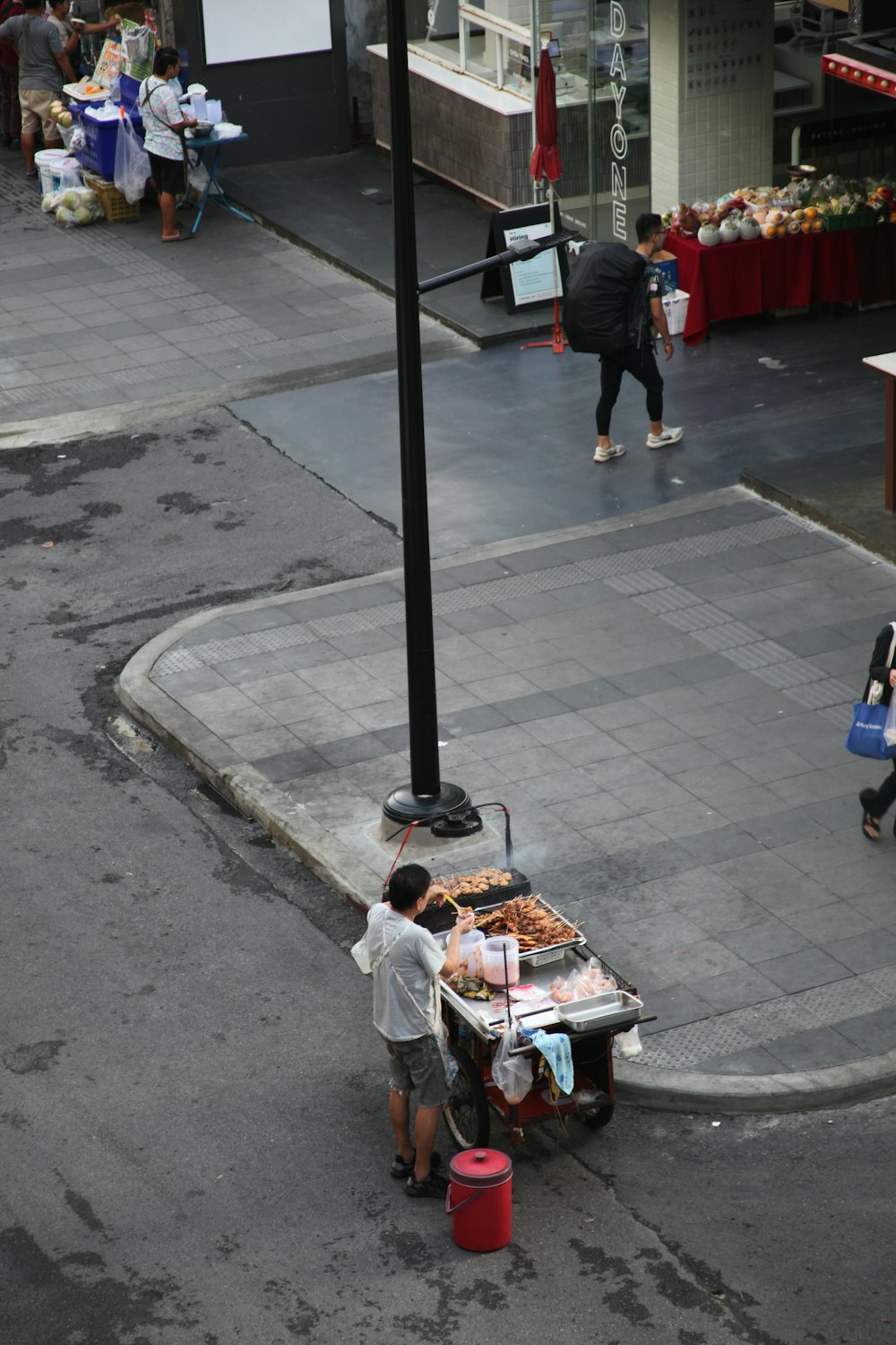 a man pushing a cart full of food down a street