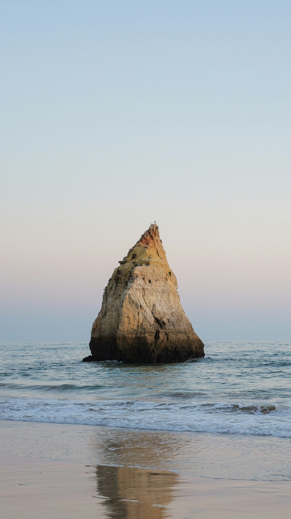 a large rock sticking out of the ocean