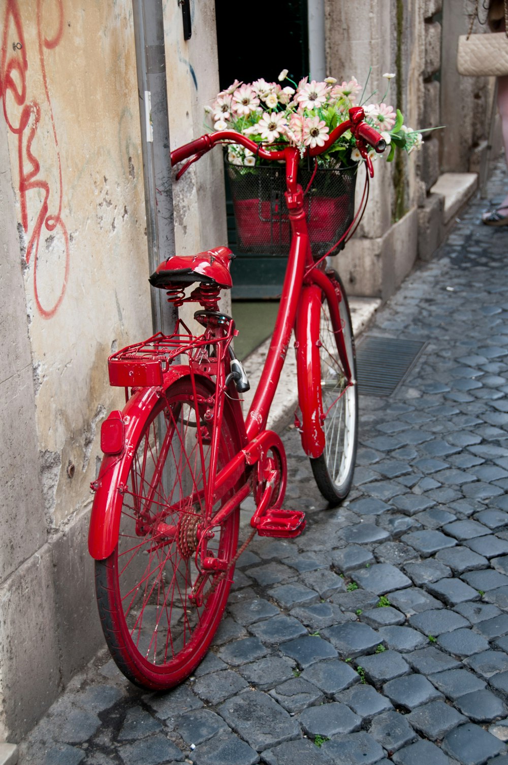 a red bicycle with a basket full of flowers