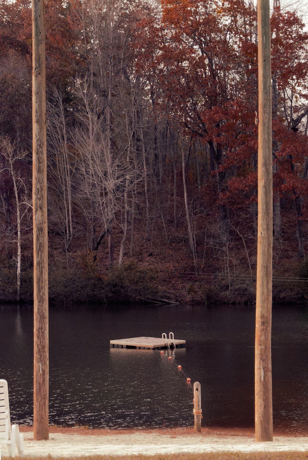 a dock in the middle of a lake surrounded by trees