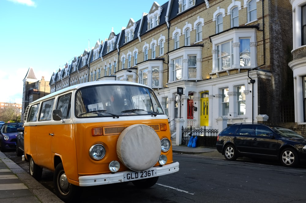 an orange and white van parked on the side of a road