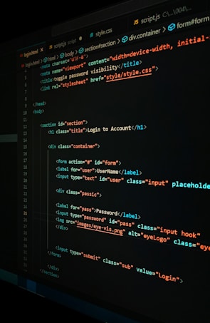 A close-up view of a computer screen displaying HTML and CSS code for a login form. The code includes elements like head, body, various input fields for username and password, and linked style sheets. The text is primarily in blue, white, orange, and green, set against a dark background.