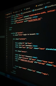 A close-up view of a computer screen displaying HTML and CSS code for a login form. The code includes elements like head, body, various input fields for username and password, and linked style sheets. The text is primarily in blue, white, orange, and green, set against a dark background.