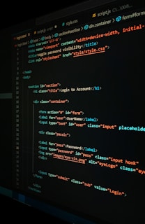 A close-up view of a computer screen displaying HTML and CSS code for a login form. The code includes elements like head, body, various input fields for username and password, and linked style sheets. The text is primarily in blue, white, orange, and green, set against a dark background.