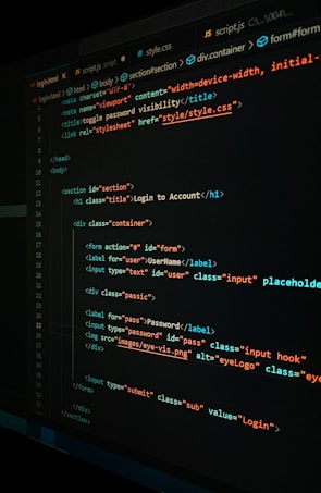 A close-up view of a computer screen displaying HTML and CSS code for a login form. The code includes elements like head, body, various input fields for username and password, and linked style sheets. The text is primarily in blue, white, orange, and green, set against a dark background.