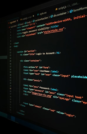 A close-up view of a computer screen displaying HTML and CSS code for a login form. The code includes elements like head, body, various input fields for username and password, and linked style sheets. The text is primarily in blue, white, orange, and green, set against a dark background.