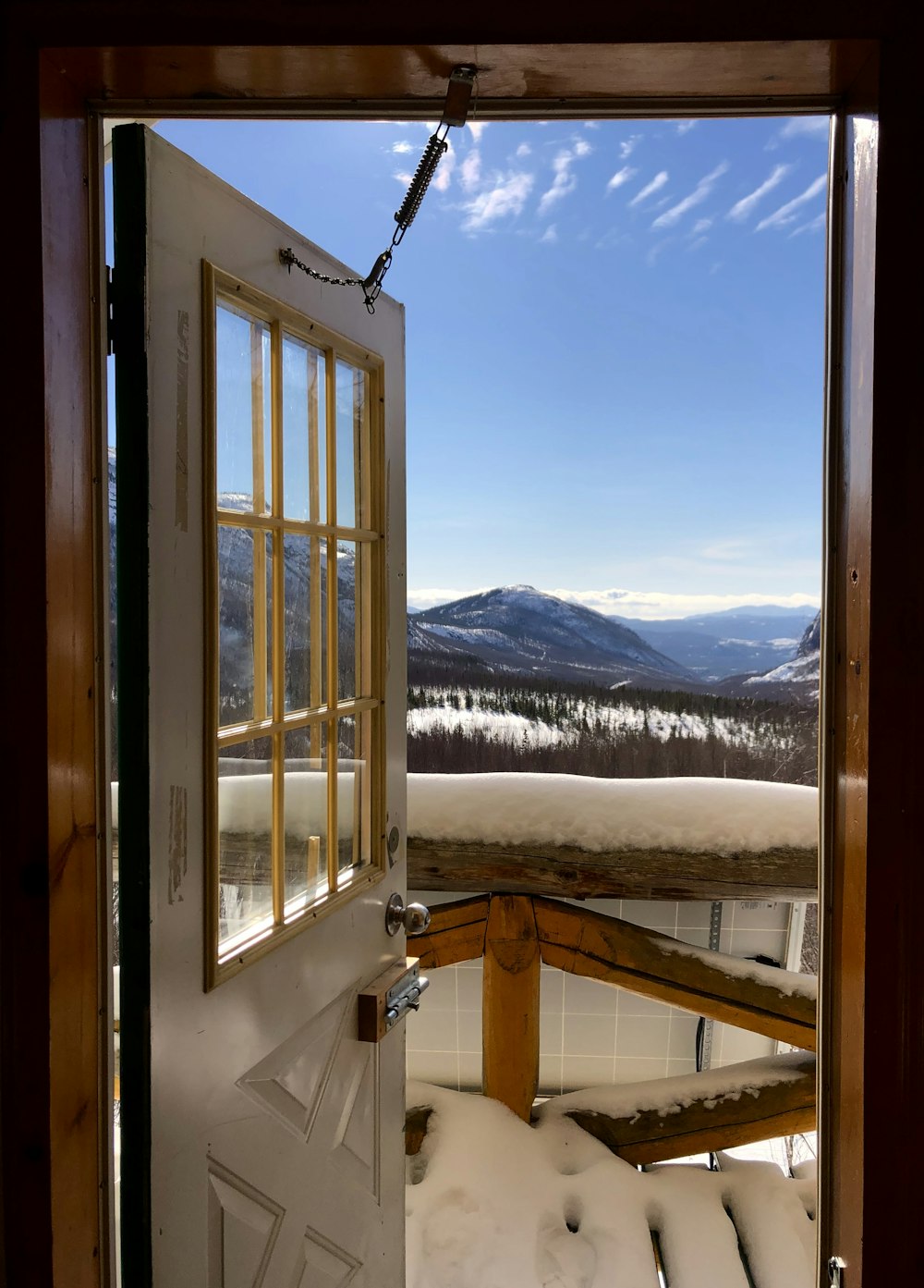 an open door leading to a snowy mountain view