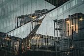 Darkened abstract image of modern glass building facades reflecting minimal light.