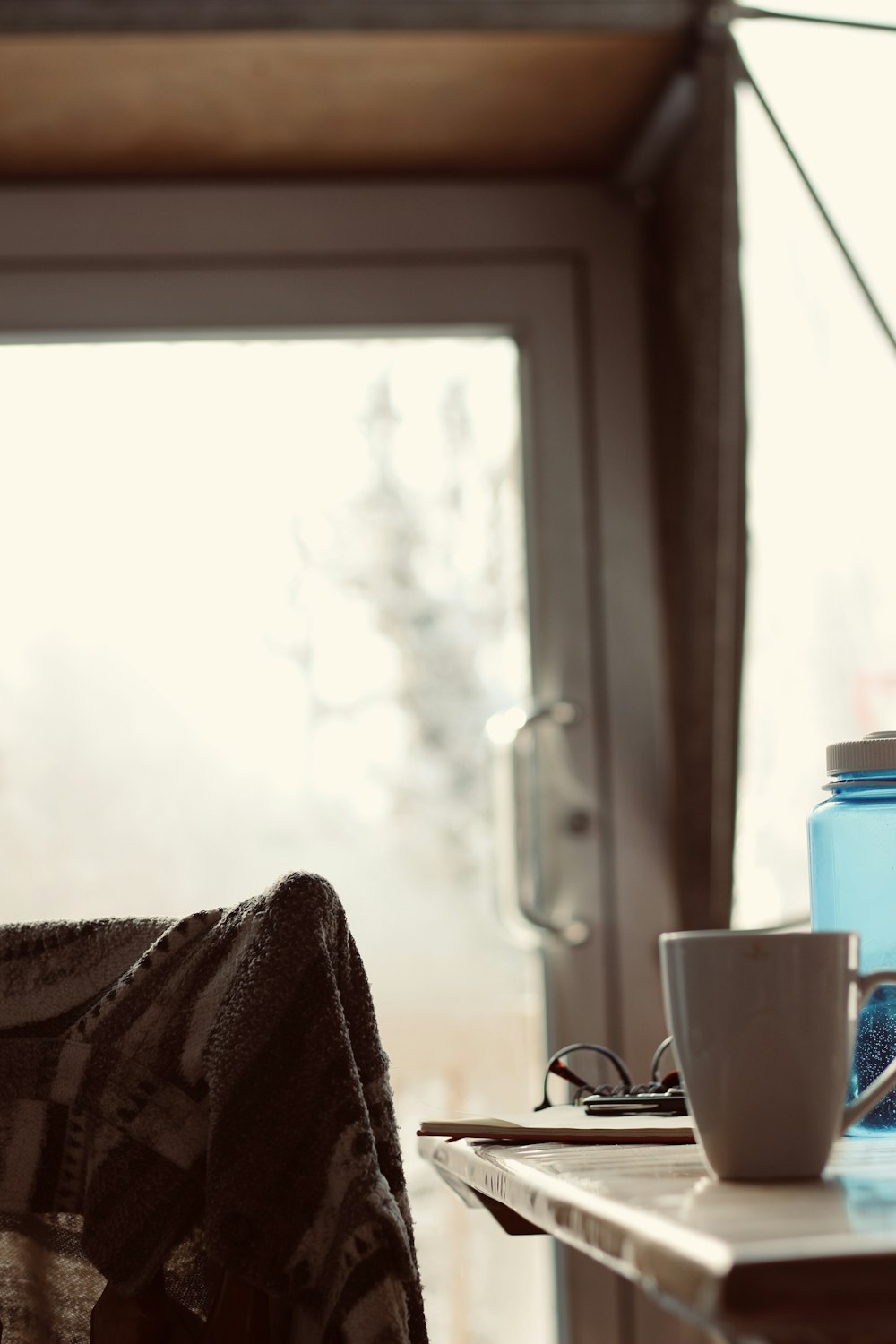 a table with a coffee cup and a water bottle on it