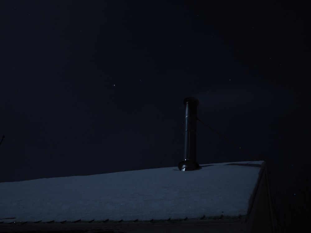 a person on a snowboard on top of a roof at night