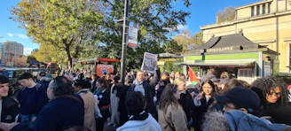 A group of enthusiastic volunteers wearing voxnova shirts, handing out flyers at a busy street corner.
