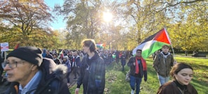 A group of volunteers planting trees in a community park during a sunny day