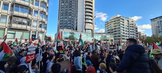 A vibrant crowd gathered outside Independence Hall in Philadelphia, waving CDC-USA flags under a clear blue sky.
