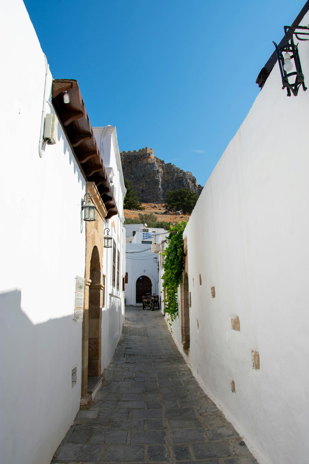 a narrow alley way with a mountain in the background